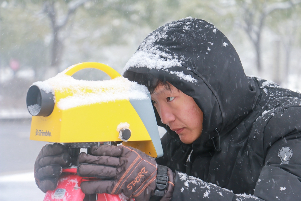 2018年1月27日，工程技术人员在雪中开展测量作业。